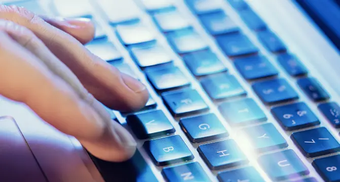 キーボードをタイピングしてシステム入力を行う手元