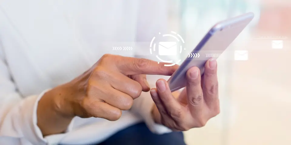 スマートフォンを操作してメッセージ送信や通知を確認する手元