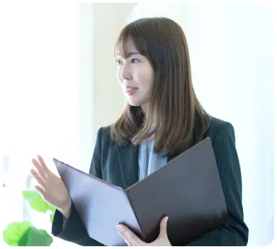 ファイルを開いて話す女性スタッフの画像